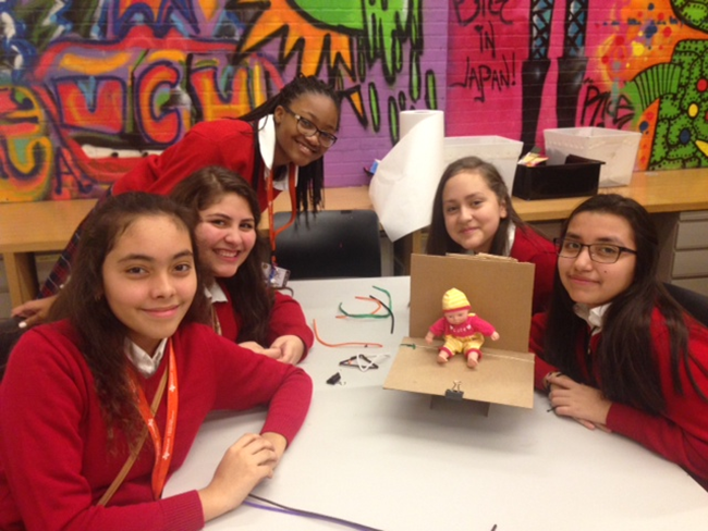 Rangel students creating a cardboard chair that can hold the weight of a doll inspired by Frank Gehry's Easy Edges chair. The catch? No glue or tape!