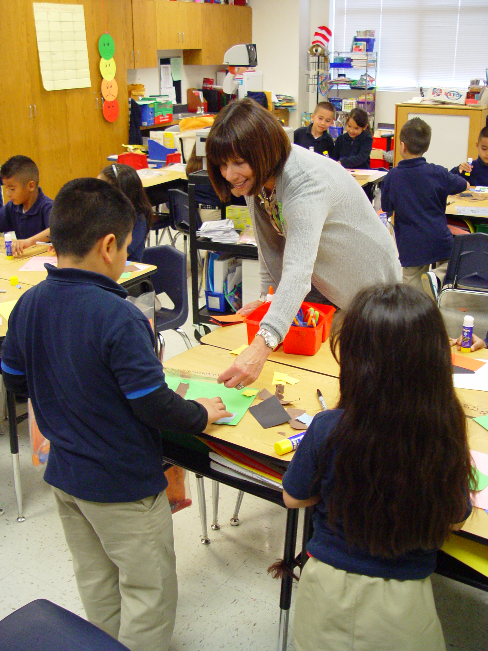 Karen, a Go van Gogh volunteer, helps students with an art project