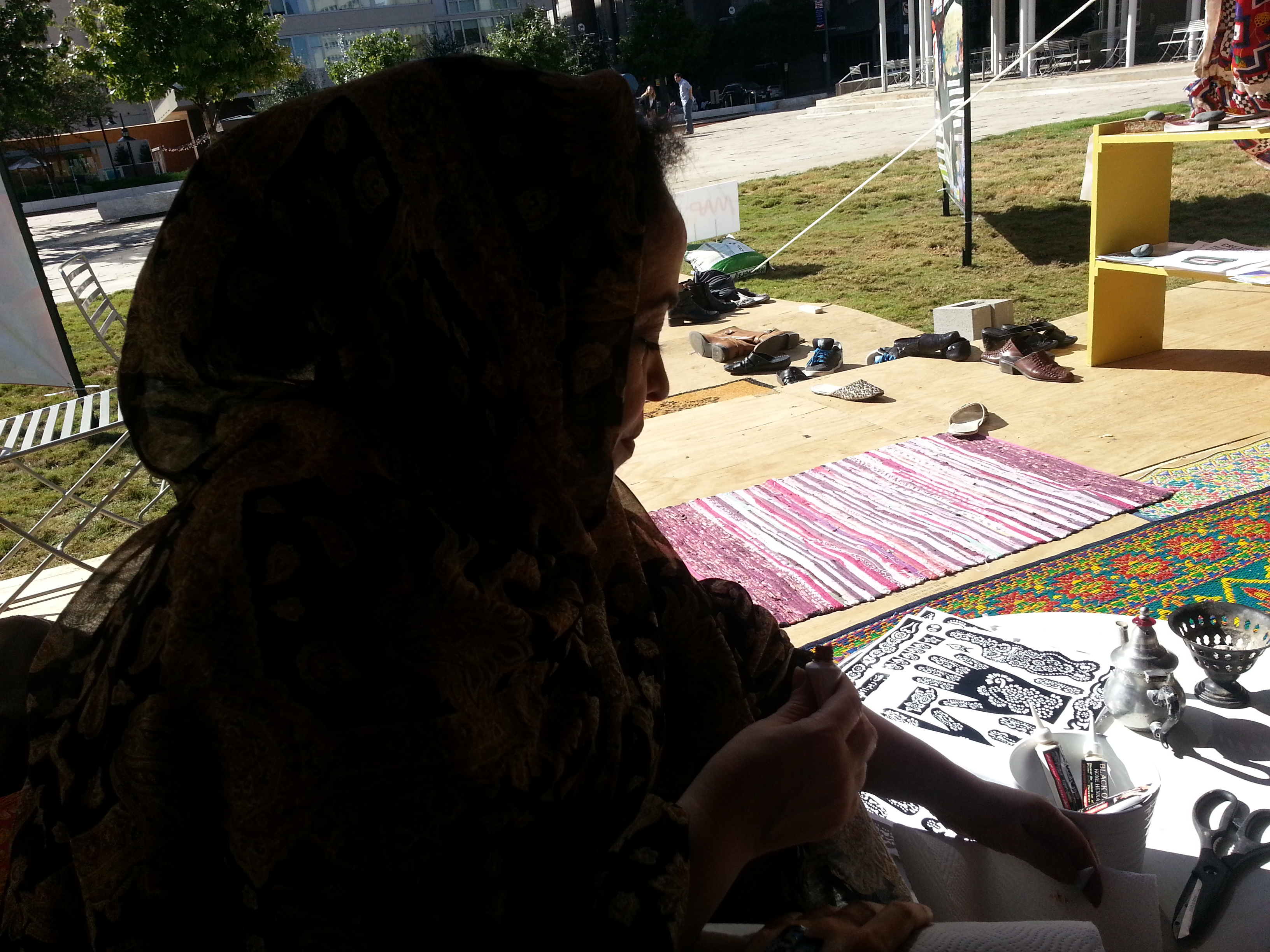 Najat prepares the stencil and henna ink for tattoos.
