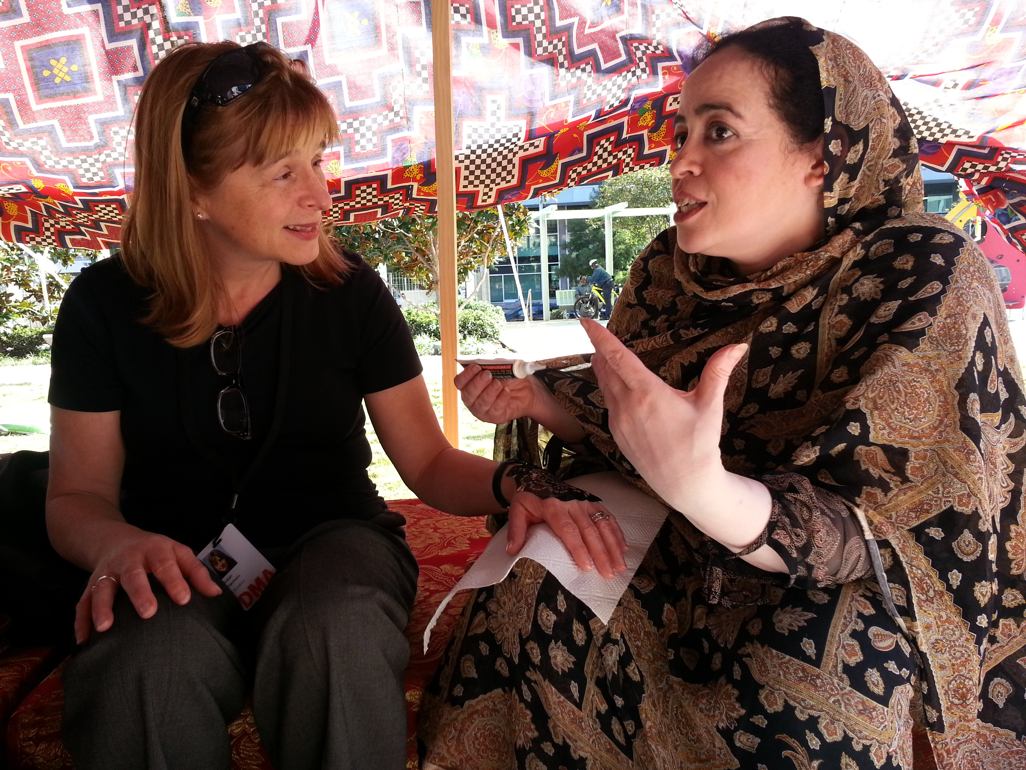 Susan and Najat chat as Susan gets her henna tattoo.