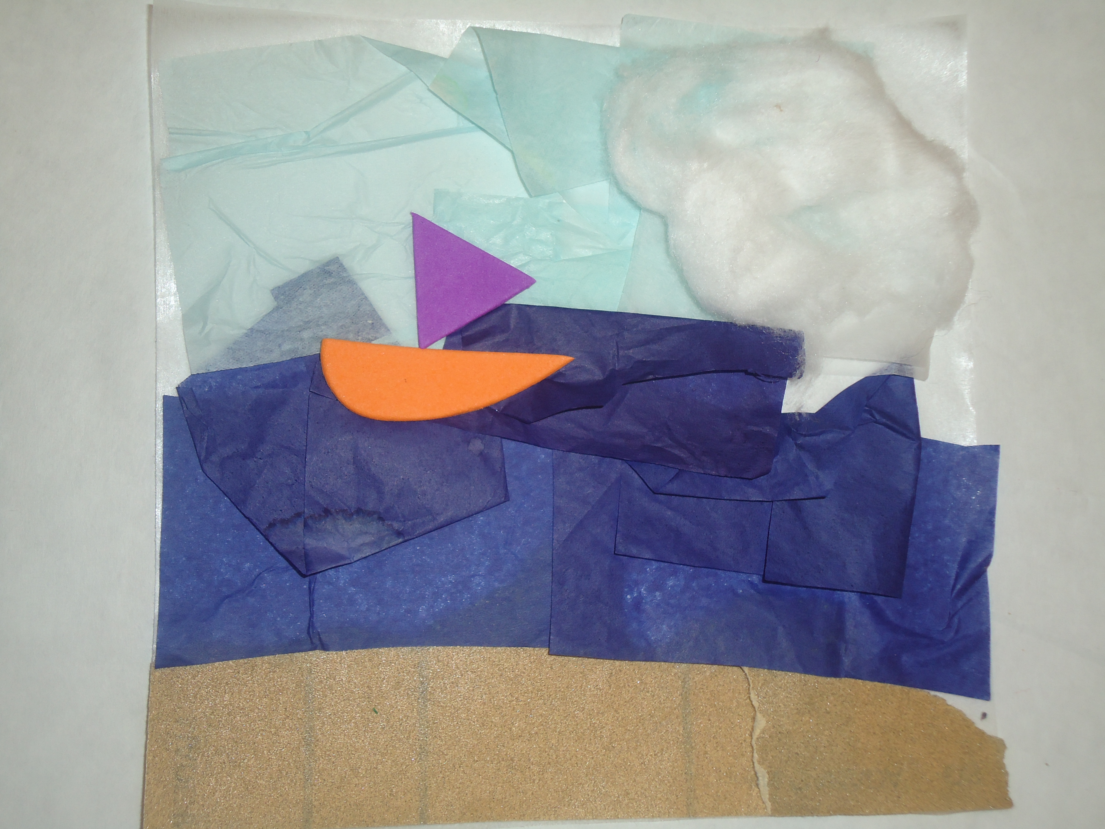 Beach scene created with sand paper, tissue paper, cotton balls, and foam shapes